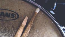 Close-up of broken drum stick that lays across an old snare drum